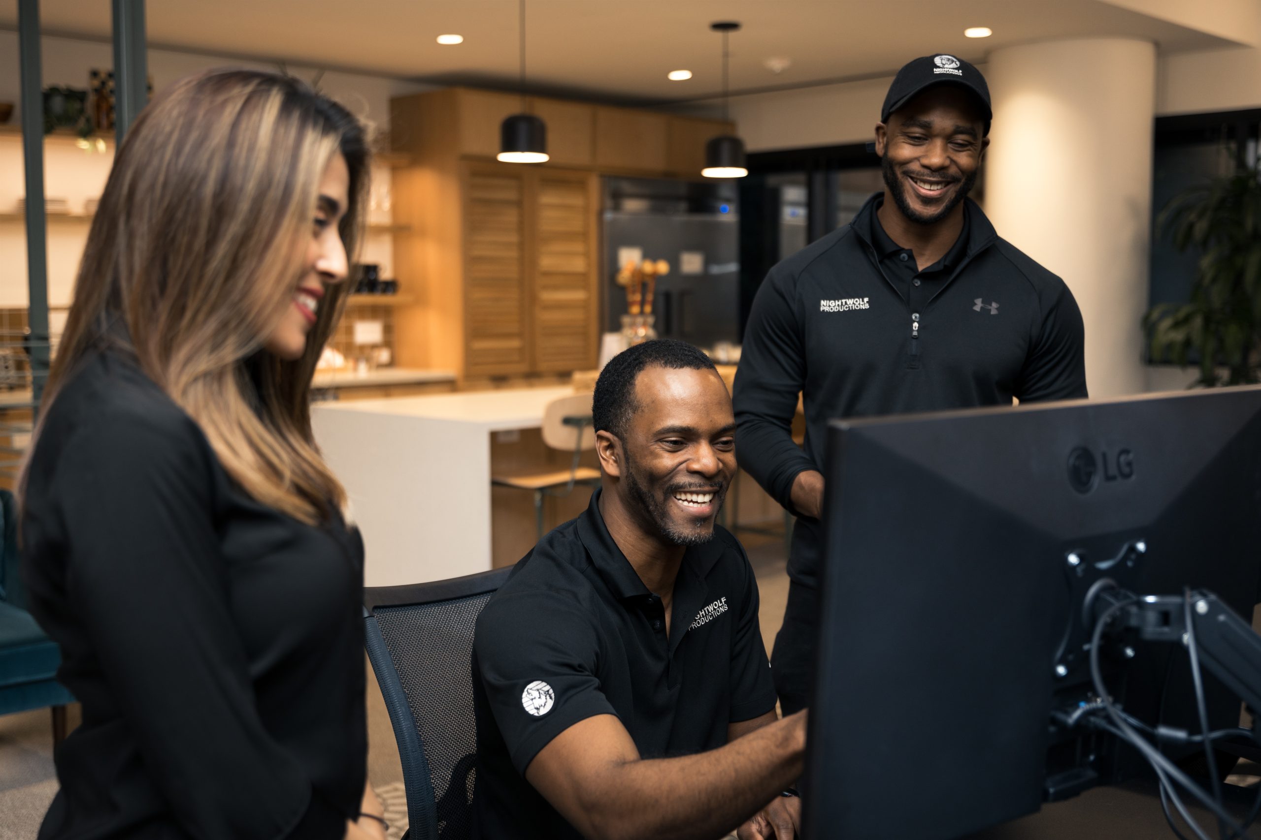 3 persons smiling while editing